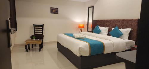a bedroom with a large bed with blue pillows at Green Club Farm in Ajmer