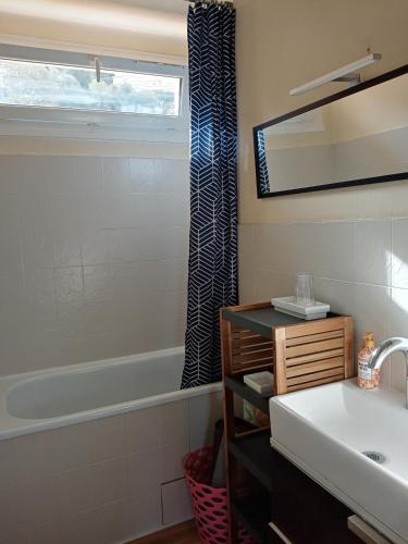 une salle de bain avec un lavabo, une baignoire et un miroir dans l'établissement Appartement Lumineux Vue Panoramique, à Ajaccio