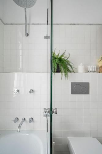 a bathroom with a shower with a tub and a sink at Newtown Nest - Chic Terrace Living off King Street in Sydney