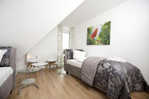 a bedroom with a bed and a table and a chair at Strandvilla "Babette" - BALO B, direkt am Meer, mit Sauna in Lobbe