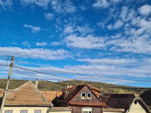 grupa domów pod niebieskim niebem z chmurami w obiekcie Margareta's House w mieście Veştem