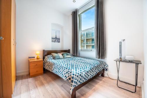1 dormitorio con cama y ventana en Cosy 1-Bed Apartment in Central London Old Street en Londres