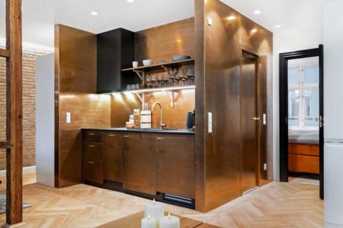 una cocina con armarios de madera y fregadero en Extravagant-2 bedrooms-Bronze en Copenhague