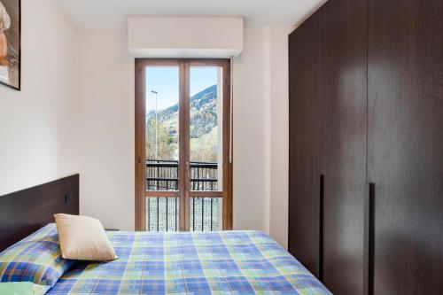 a bedroom with a bed and a large window at Le Sorgenti in Valdisotto