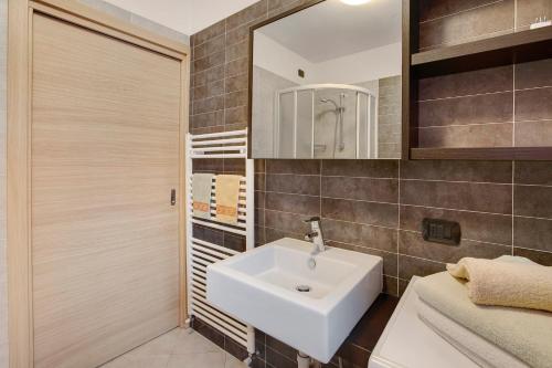 ein Badezimmer mit einem weißen Waschbecken und einem Spiegel in der Unterkunft Le Sorgenti in Valdisotto