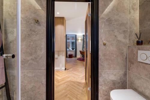 a bathroom with a shower and a toilet and a hallway at Cherryy in Copenhagen
