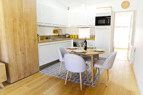 une cuisine avec une table et des chaises dans une cuisine dans l'établissement Fondaudège - Appartement 1 chambre avec parking, à Bordeaux