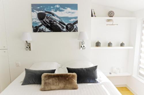 - une chambre blanche avec un lit blanc et des oreillers noirs dans l'établissement Fondaudège - Appartement 1 chambre avec parking, à Bordeaux