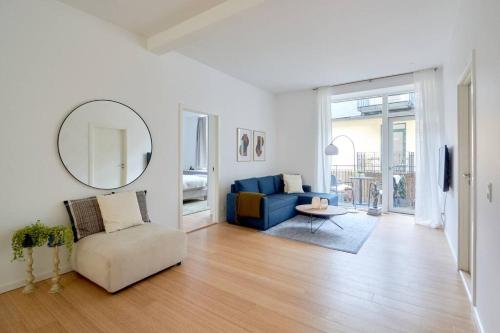 a living room with a blue couch and a mirror at Nordic style top location balcon in Copenhagen