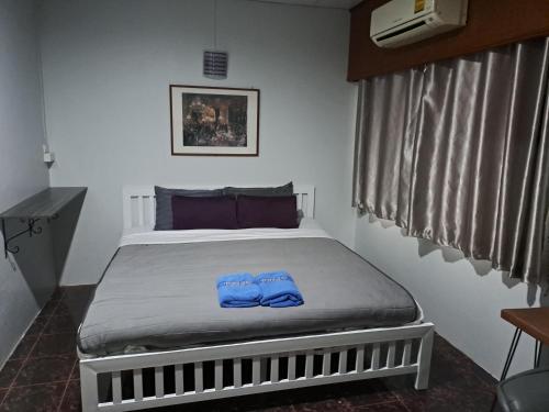 Un dormitorio con una cama con pantalones azules. en PPS.Guest House en Lop Buri