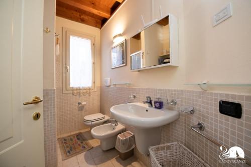 een badkamer met een wastafel en een toilet bij Borgo del Torchio - App. 5H in Manerba del Garda