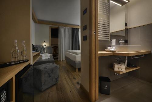 a bathroom with a sink and a couch in a room at Hotel Galli's - Centro in Livigno