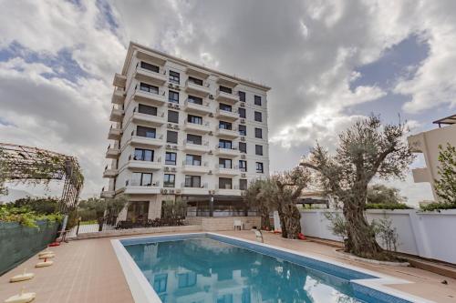 un hôtel avec une piscine en face d'un bâtiment dans l'établissement Hotel Pharos, à Bar