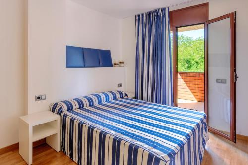 um quarto com uma cama e uma porta de vidro deslizante em Tossa dreams em Tossa de Mar