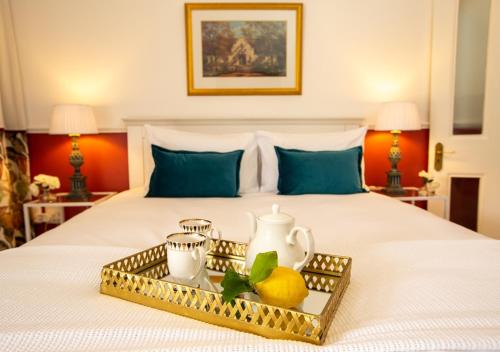 a bed with a tray with a tea pot and lemons on it at Hotel du Vin Franschhoek in Franschhoek