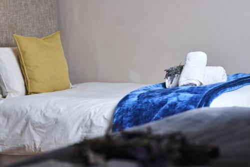 a bed with a blue blanket and towels on it at De Akker Guest House Oudtshoorn in Oudtshoorn