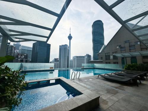 a swimming pool with a view of the city at Cormar KLCC by NHB in Kuala Lumpur
