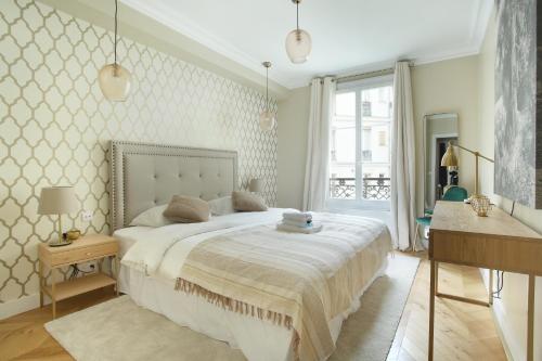 une chambre avec un grand lit blanc et une fenêtre dans l'établissement Apartment Opéra by Studio prestige, à Paris