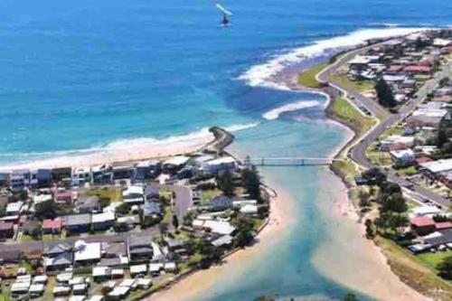 an aerial view of a beach with houses and the ocean at Sandcastles in Barrack Point