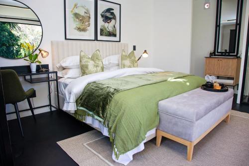 a bedroom with a large bed with a green blanket at Paarl Hideaway in Paarl