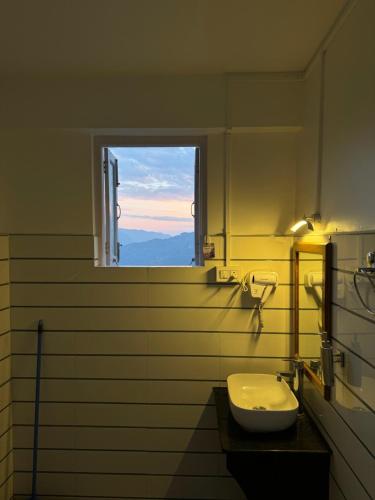 baño con lavabo y ventana en Addy's Inn en Gangtok