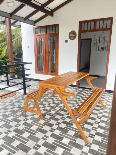 uma mesa de piquenique em madeira sentada num pátio em Akeinya villa em Galle