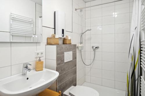a white bathroom with a sink and a shower at 1 Zi. Wohnung, 34m², Parken, Messe DUS in Duisburg