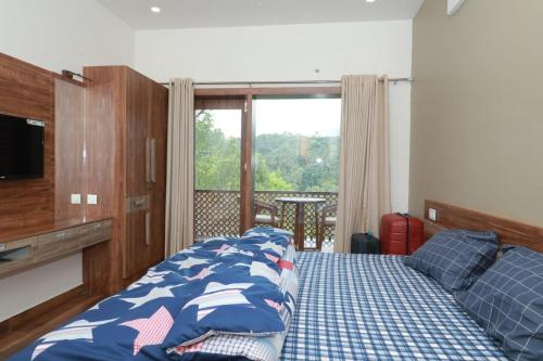 a bedroom with a bed and a television and a balcony at WinterHome homestay in Munnar
