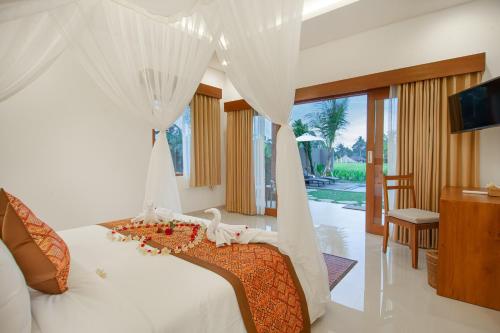 un dormitorio con una cama con dosel en Palasari Villa by Prasi, en Tegalalang