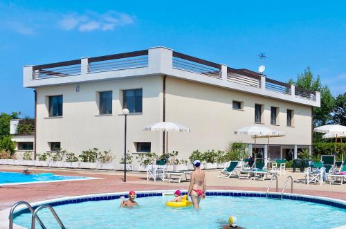 un grupo de personas en la piscina de un complejo en ISA-Apartments for 4 people, 2 bedrooms, in Residence with swimming pool in San Vincenzo, just 600 meters from the sea, en San Vincenzo
