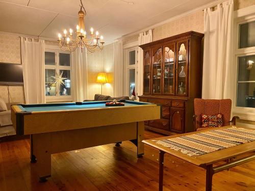 a living room with a pool table and a chandelier at Apotekbygget in Nesbyen