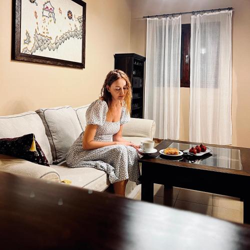 a woman sitting on a couch in a living room at The Knight and the Pomegranate - Luxury Medieval Villa in Rhodes Town