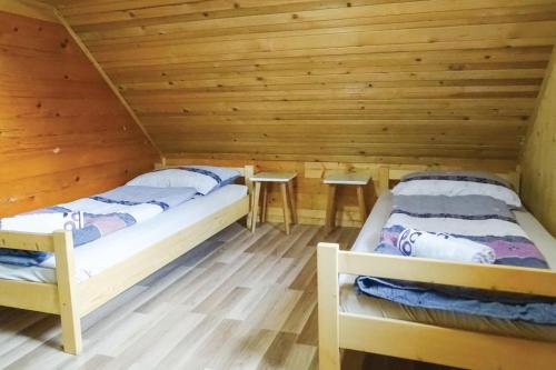 2 letti in una camera con pareti in legno di Mountain Lodge Jelje - Happy Rentals a Zgornje Gorje