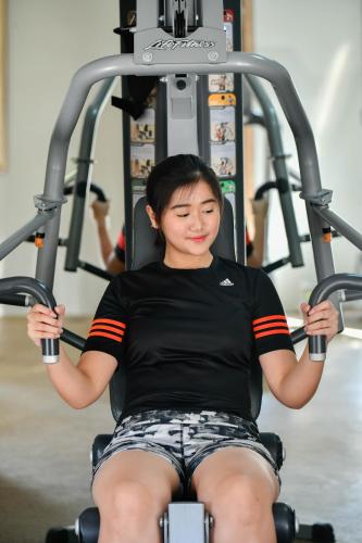 a woman sitting in a gym on a treadmill at Rama Residence Petitenget in Seminyak