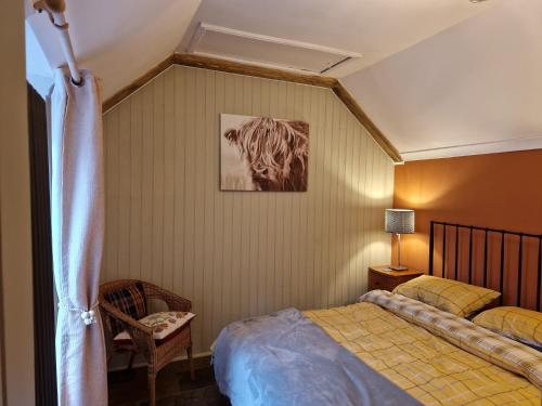 a bedroom with a bed and a picture on the wall at Coopers Cottage in Peterhead