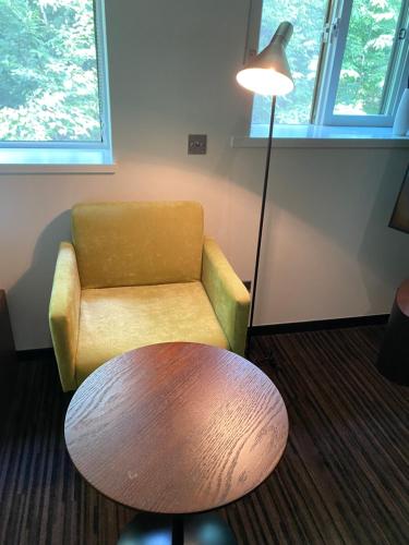 a room with a chair and a table and a lamp at ユニテ蔵王ジョーニダ リゾート in Yamagata