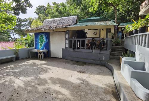 a small house with a porch and a table at Mario's Scuba Diving and Homestay in Apo Island