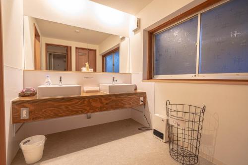 a bathroom with two sinks and a large mirror at 4S STAY Awaikeda Ekimae in Miyoshi