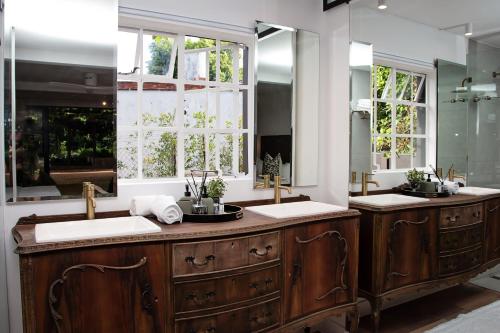 a bathroom with two sinks and two mirrors at Paarl Hideaway in Paarl