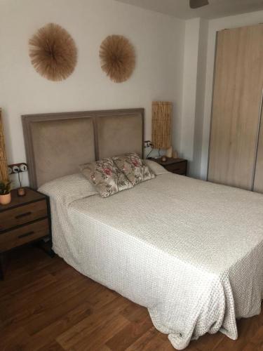 a bedroom with a bed and two baskets on the wall at ATICO RIO GENIL in Cenes de la Vega