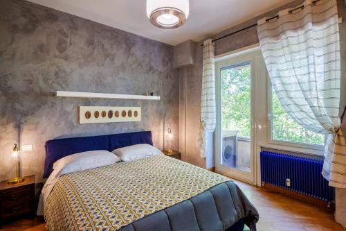 een slaapkamer met een blauw bed en een raam bij appartamento a Testaccio in Rome