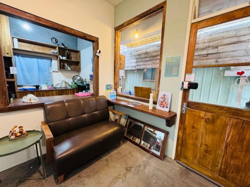 a living room with a leather couch and a table at MatchBox Hostel in Longjing