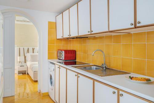 cocina con fregadero y lavavajillas en Residence Le Axidie, en Vico Equense