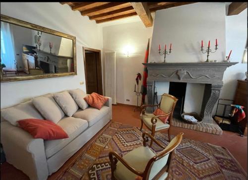 sala de estar con sofá blanco y chimenea en Casa Logge del Vasari, en Arezzo