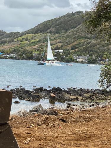 um veleiro em um corpo de água com um barco em Ashan Luxury Seafront Villa 1 em Grande Rivière Sud Est