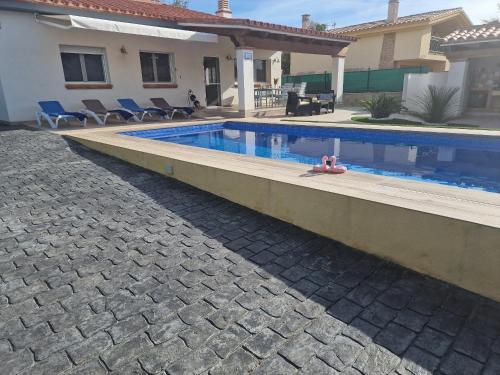 a swimming pool in front of a house at Riumar Sueno, 270m to beach, Privat-Pool, On-Site-Service, dog beach in Riumar