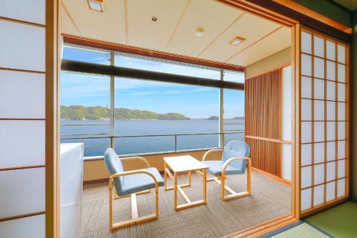 a balcony on a cruise ship with a table and chairs at Ooedo Onsen Monogatari Nanki Kushimoto in Kushimoto