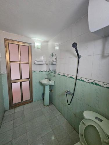 a bathroom with a shower and a toilet and a sink at Nhà Nghỉ Thái Thu in Cao Bằng