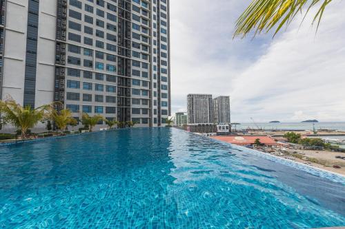a large swimming pool in front of a tall building at HayBay Jesselton Quay Deluxe Seaview Suite 海景观 in Kota Kinabalu