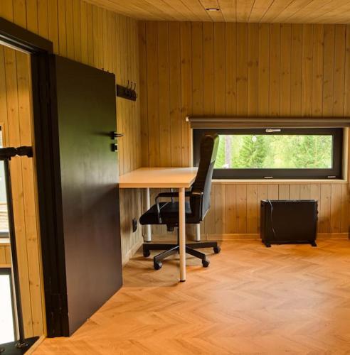 an office with a desk and a chair and a window at Skogly - Ny stor hytte, Unike Finnskogen in Torsby